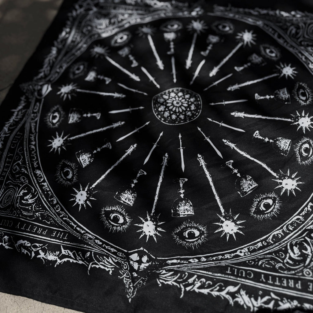 Black scarf with white symbols and designs on a textured surface