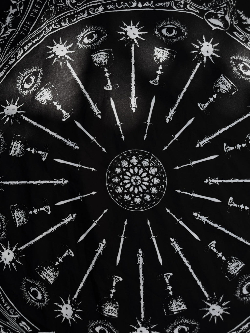 Decorative plate with black and white geometric patterns and symbols on a dark background