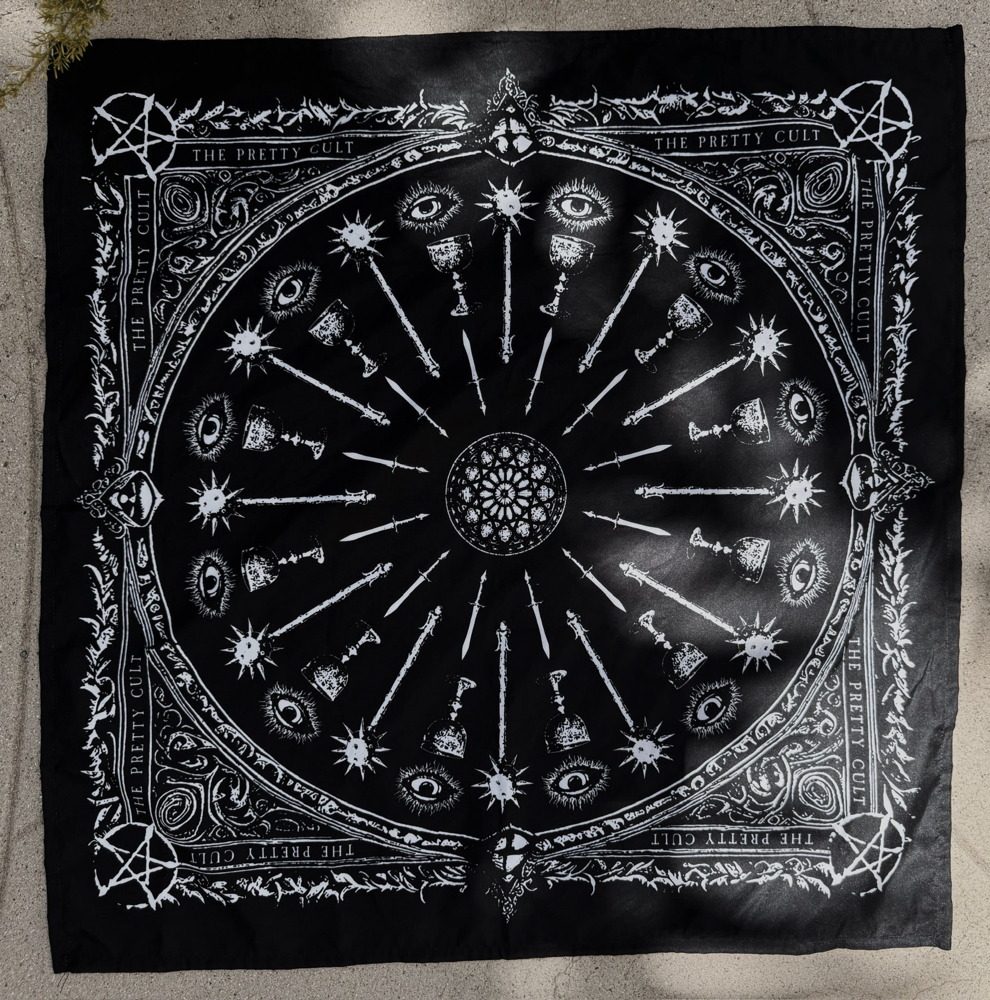 Black scarf with white intricate design on a textured surface