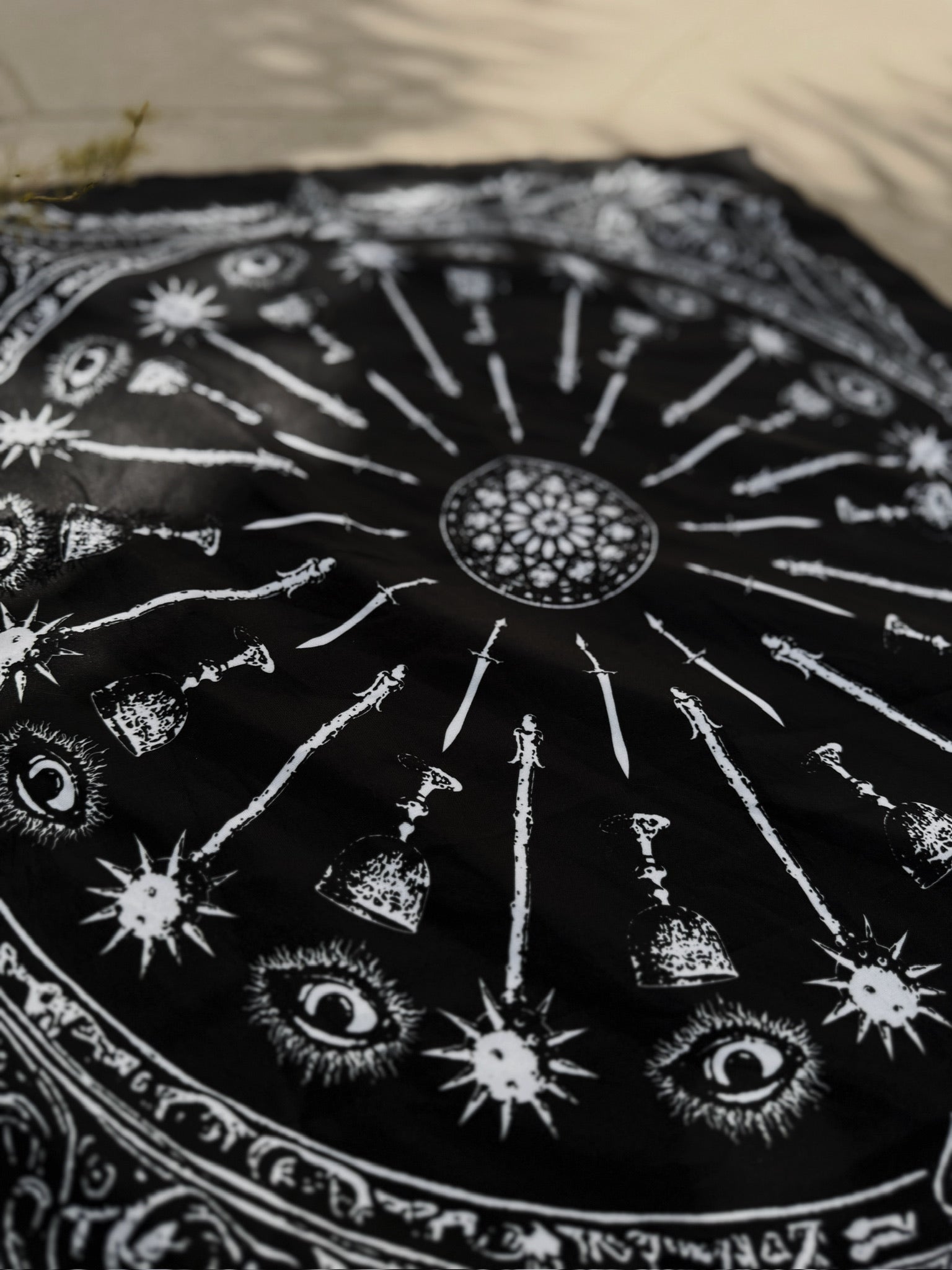 Black and white mandala with celestial symbols on a textured surface