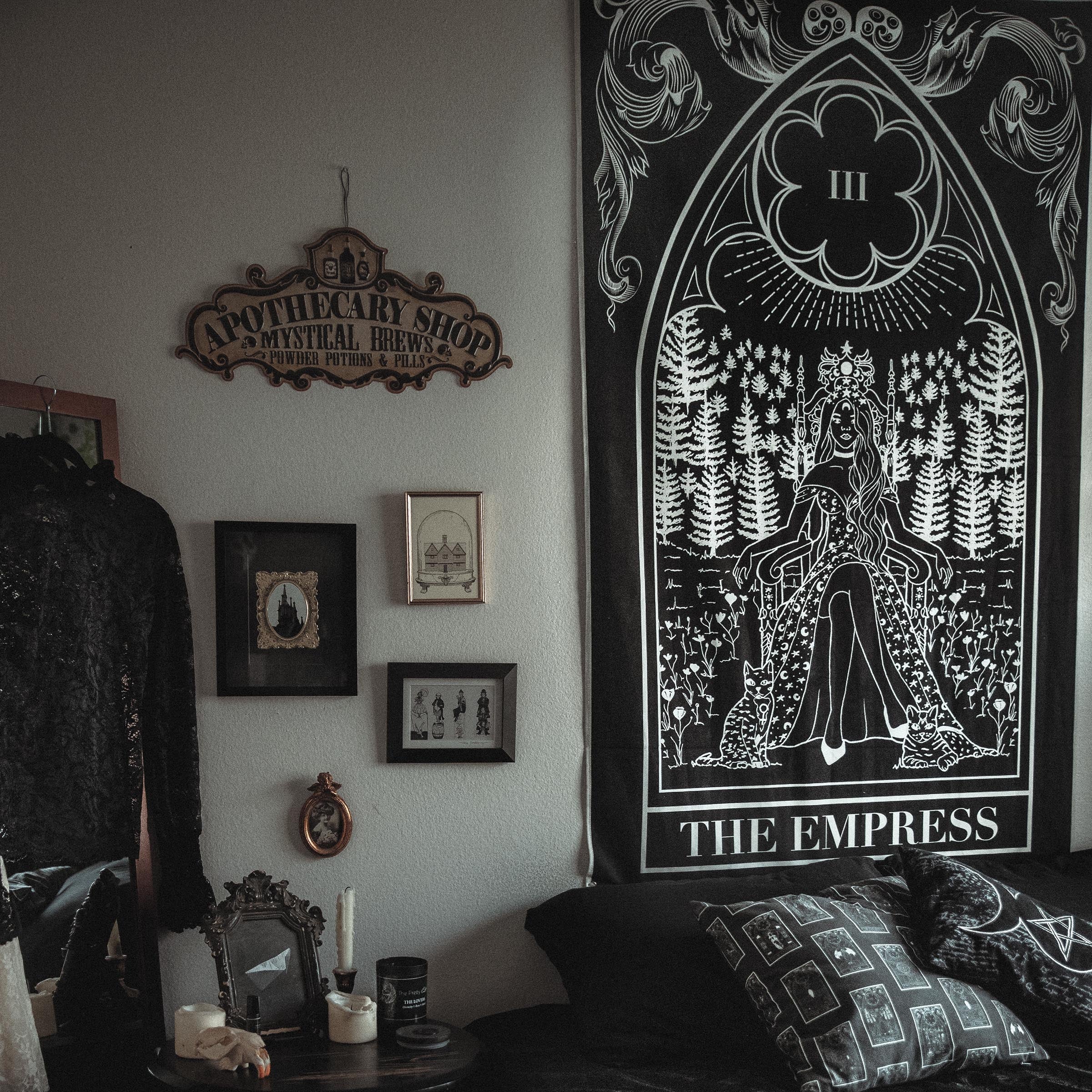 Dark-themed bedroom with 'The Empress' tarot card tapestry on the wall.