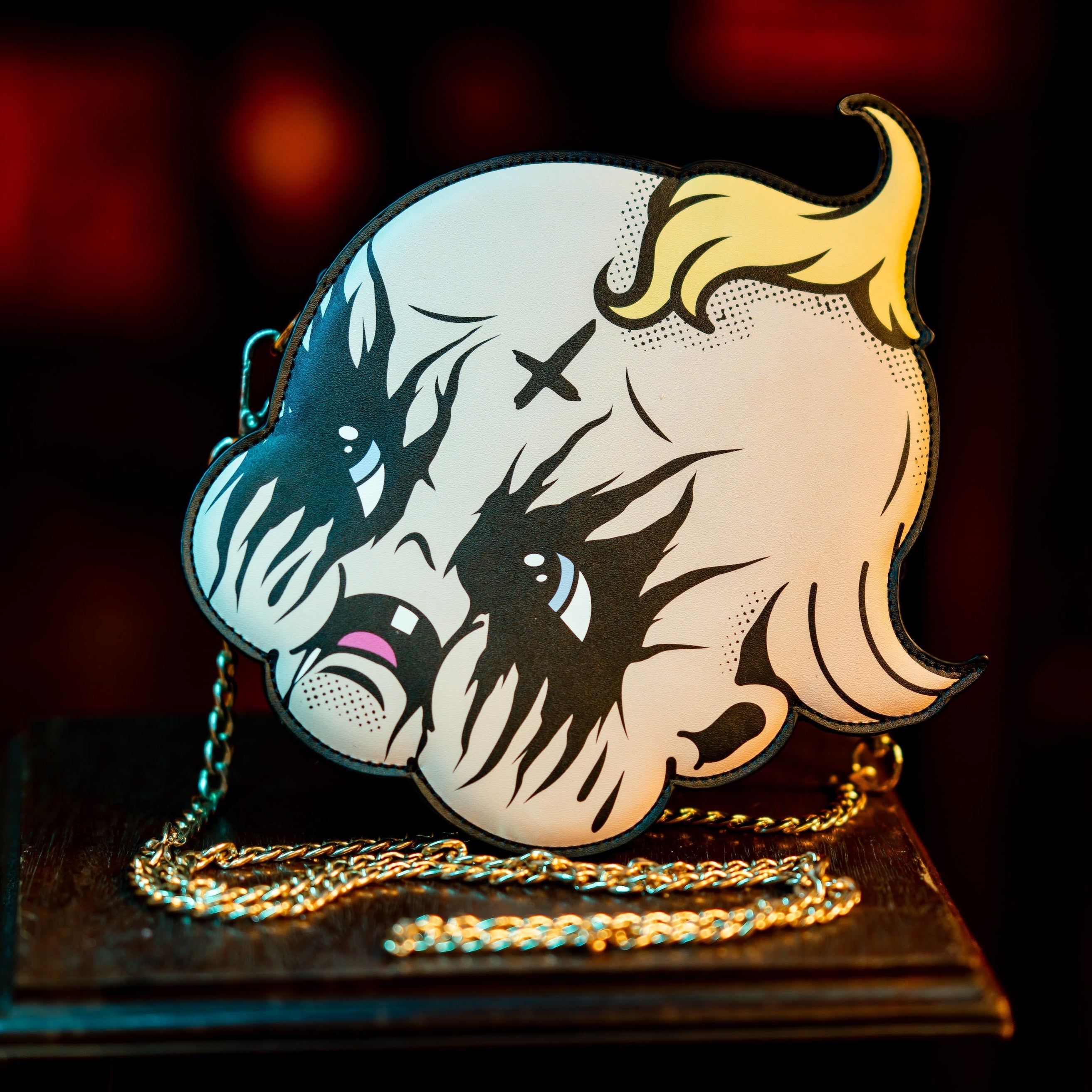 Handbag with a stylized face design on a dark background