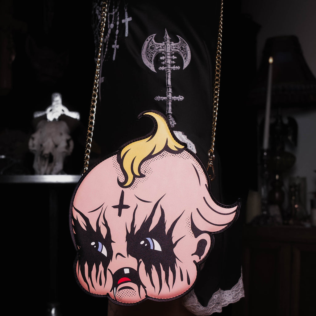 Person holding a bag with a cartoon character design featuring blonde hair and black eyes.