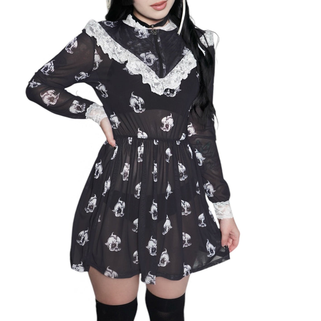 Person wearing a black dress with white patterns and knee-high boots on a white background