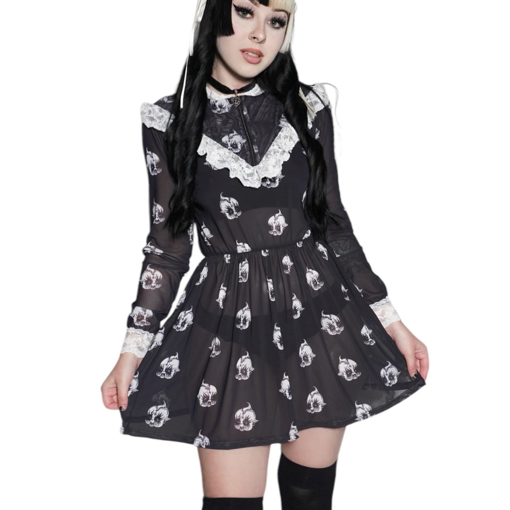 Person wearing a black dress with white patterns on a white background