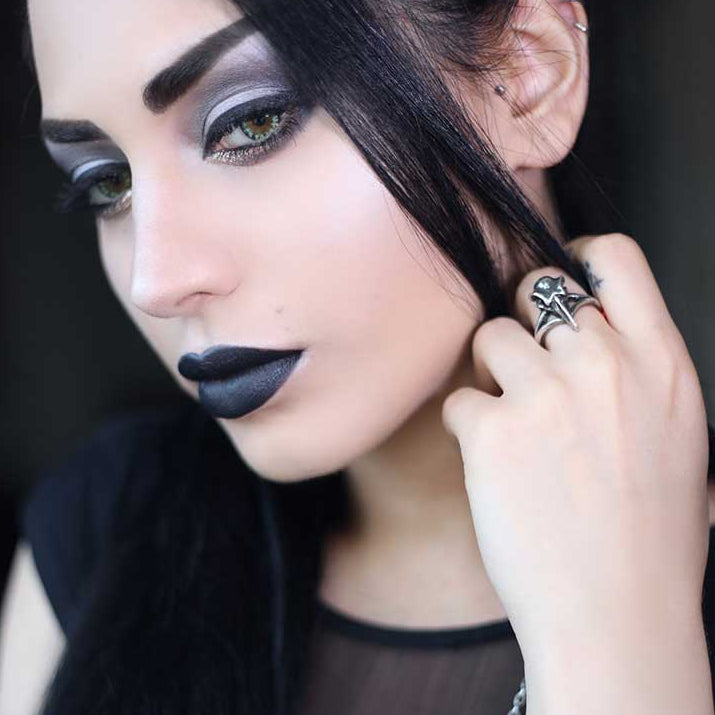 Silver ring with intricate design on a white background