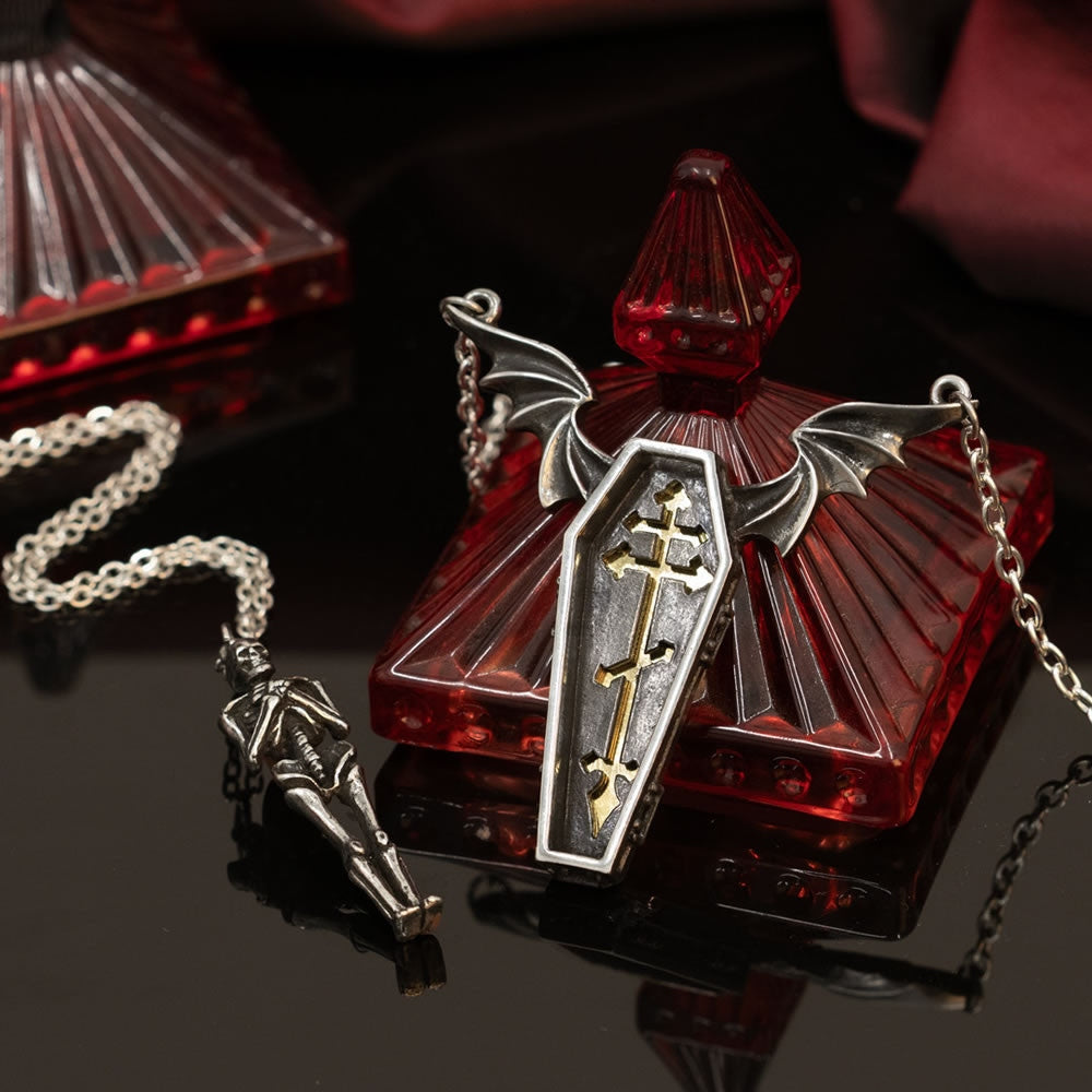 Silver skeleton pendant necklace on a white background