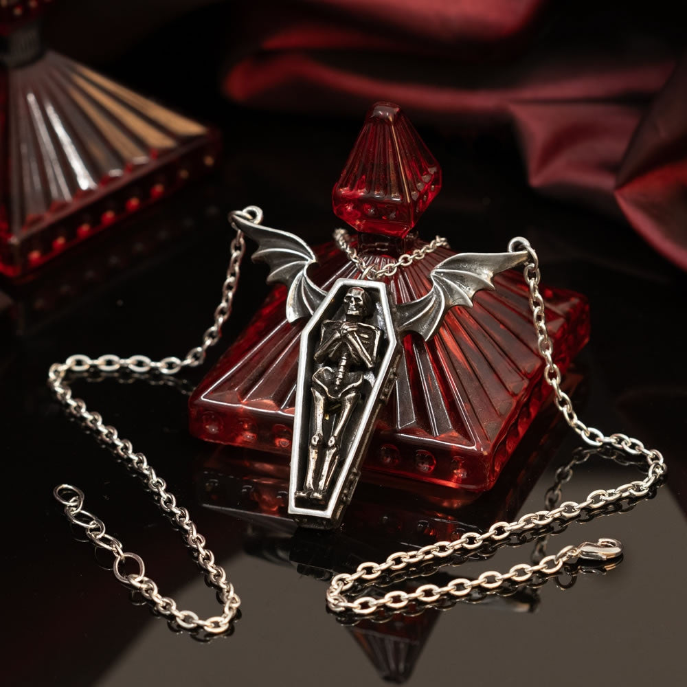 Silver skeleton pendant necklace on a white background