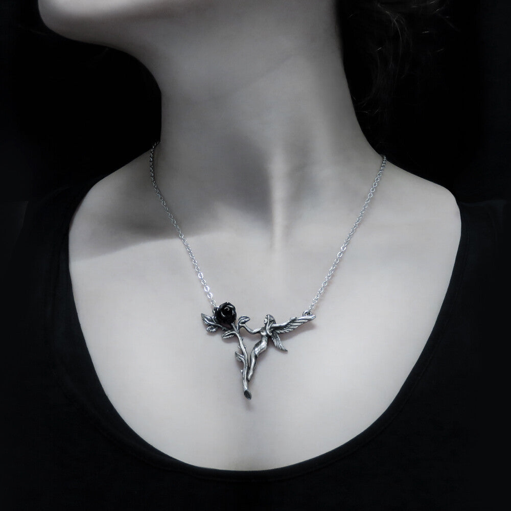 Silver necklace with a black rose pendant on a mannequin neck against a black background