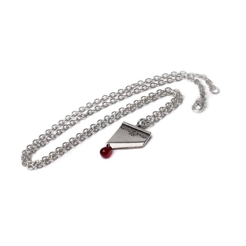Silver necklace with a pendant and red gemstone on a white background