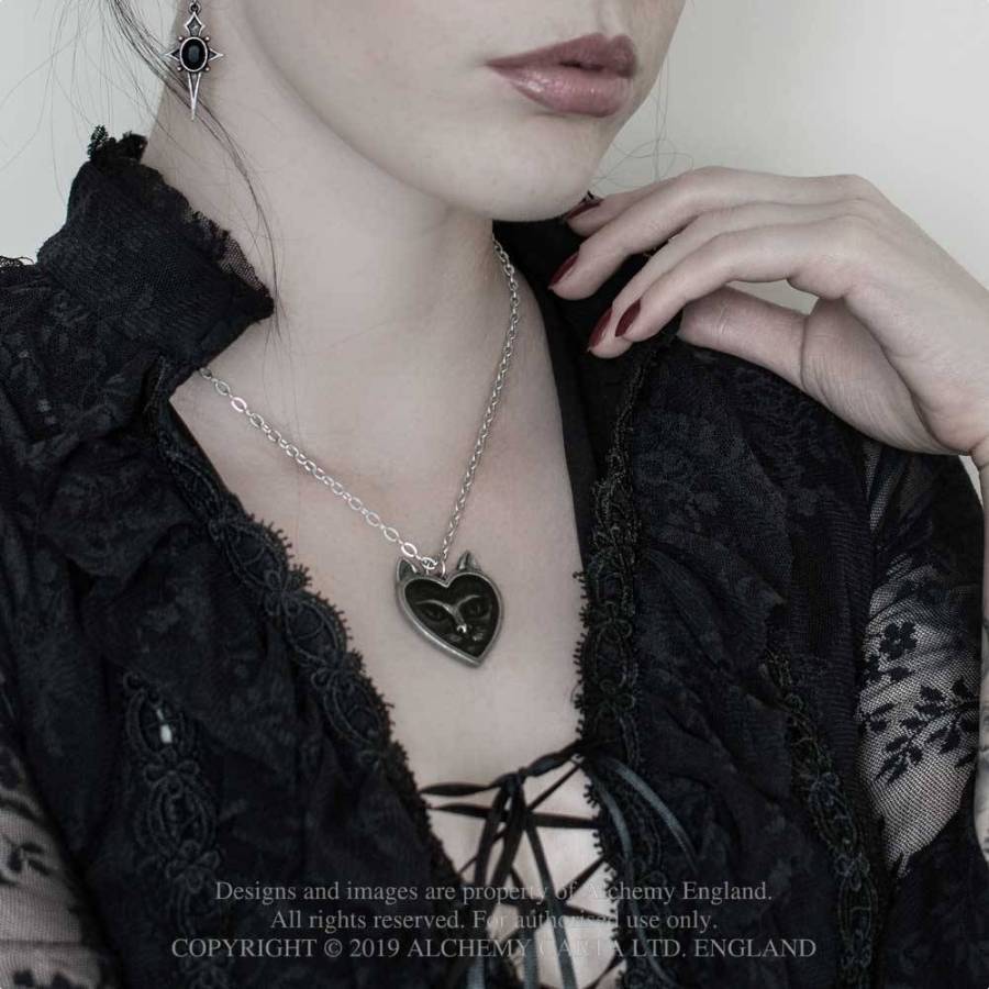 Close-up of a person wearing a black lace garment and a necklace with a heart pendant.