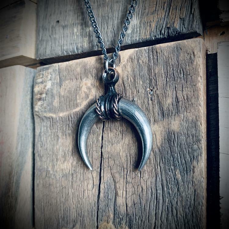 Silver necklace with a unique pendant on a wooden surface