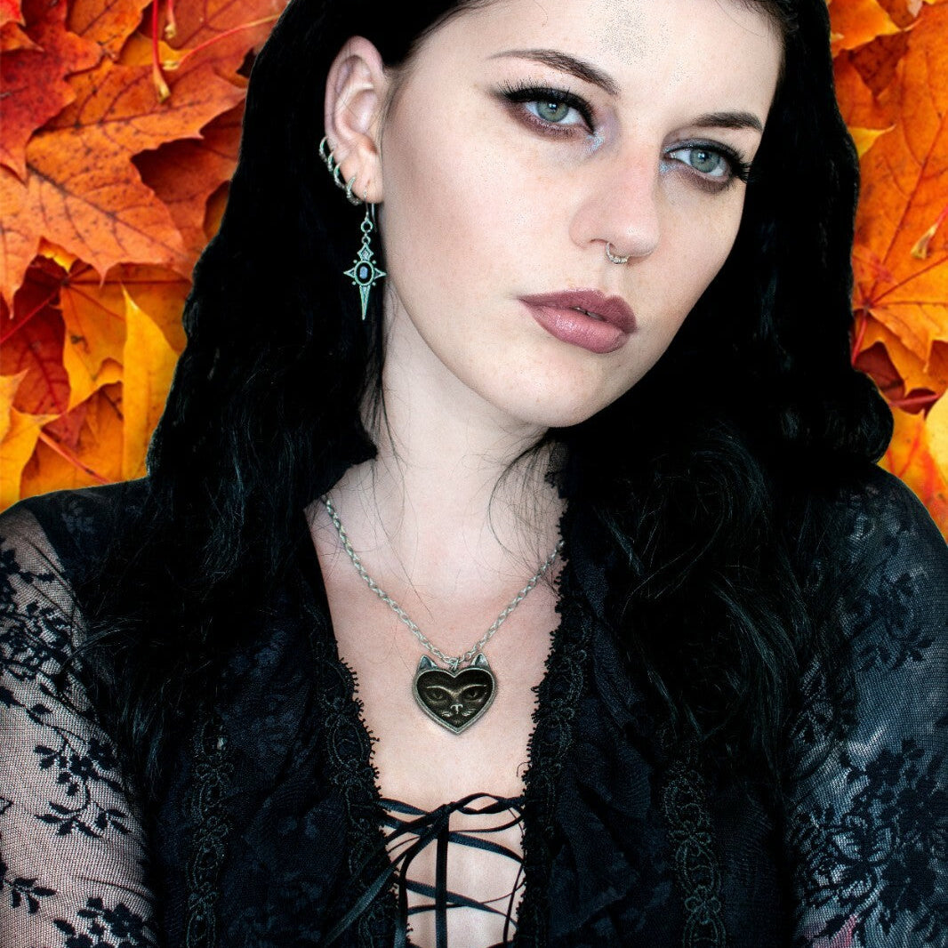 Woman with dark hair and piercings against a background of autumn leaves