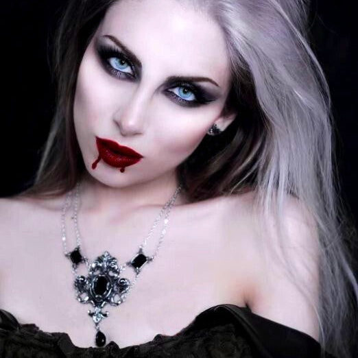 Person with gothic makeup and attire against a black background