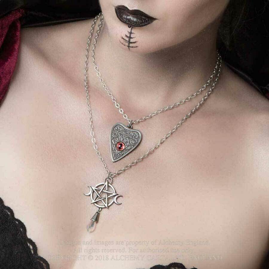 Close-up of a person wearing a silver necklace with a pentagram pendant.