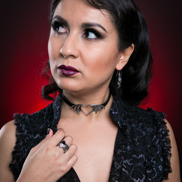 Woman wearing a black lace dress with a red background
