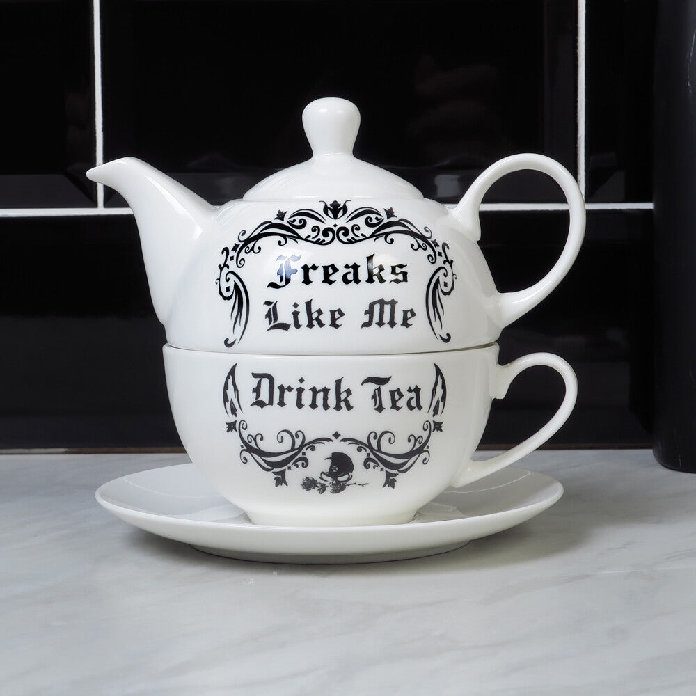 White teapot, cup, and saucer set with black text on a white surface.