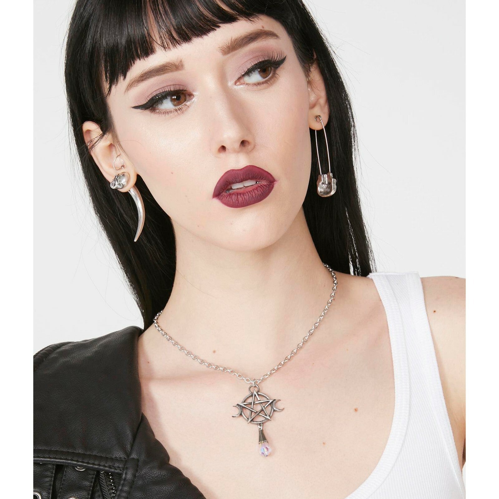 Woman wearing a silver necklace with a star pendant on a white background