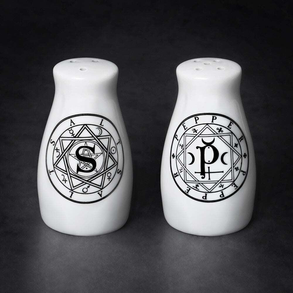 Two white salt and pepper shakers with black symbols on a dark background