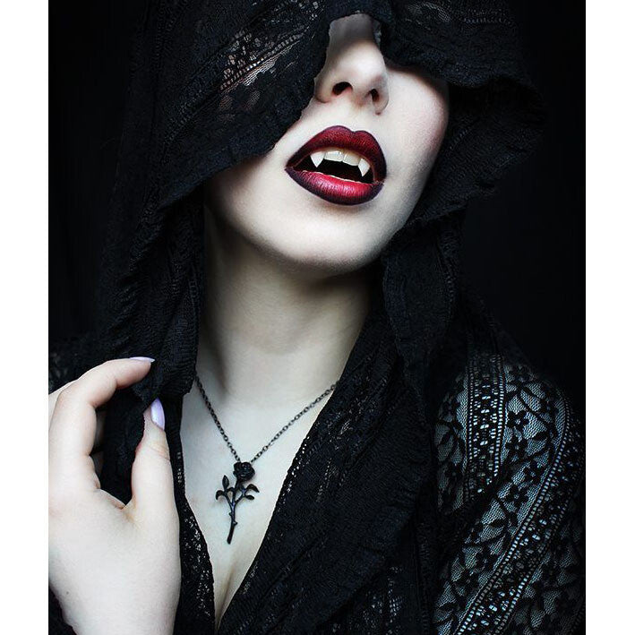 Person wearing a black lace garment with red lipstick and a dark hood.
