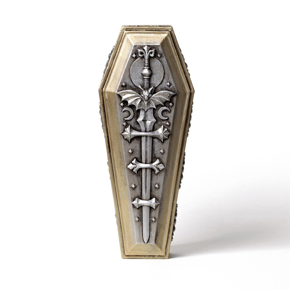 Decorative coffin-shaped object with metallic cross design on a white background