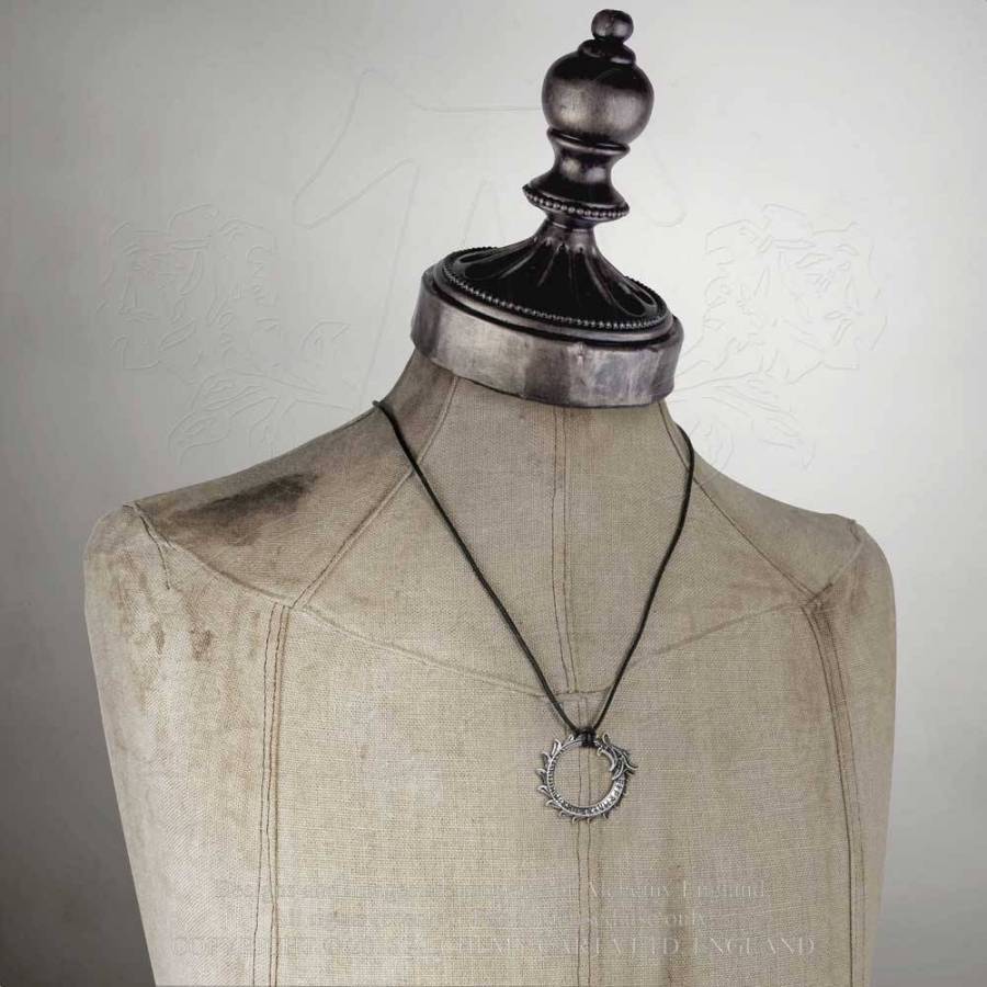 Necklace with a pendant on a mannequin bust against a plain background