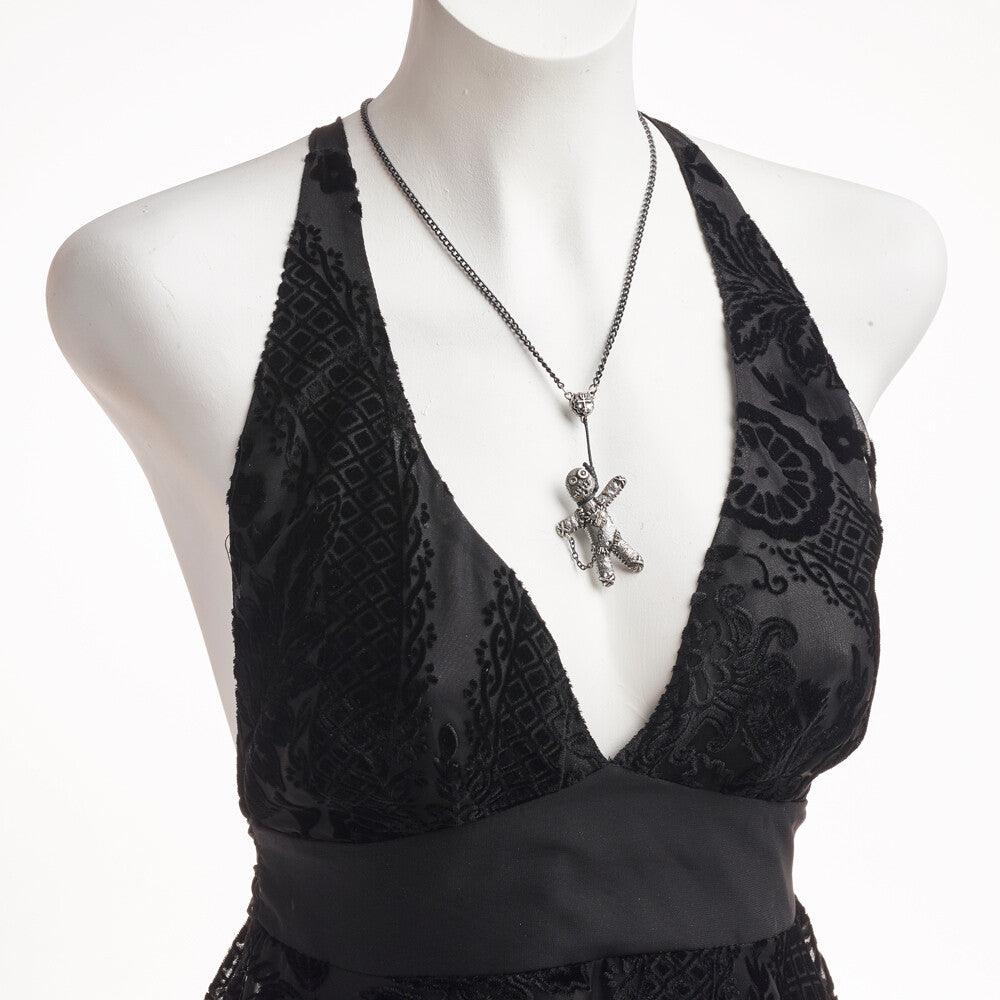 Black lace top on a mannequin with a silver necklace featuring a lizard pendant.