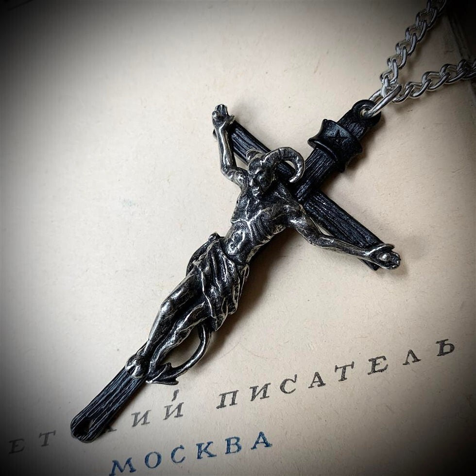 Silver crucifix pendant on a chain against a textured background with text.