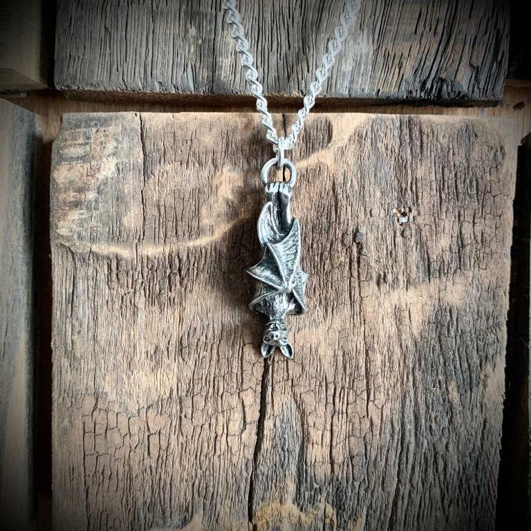 Silver dragon pendant necklace on a wooden surface