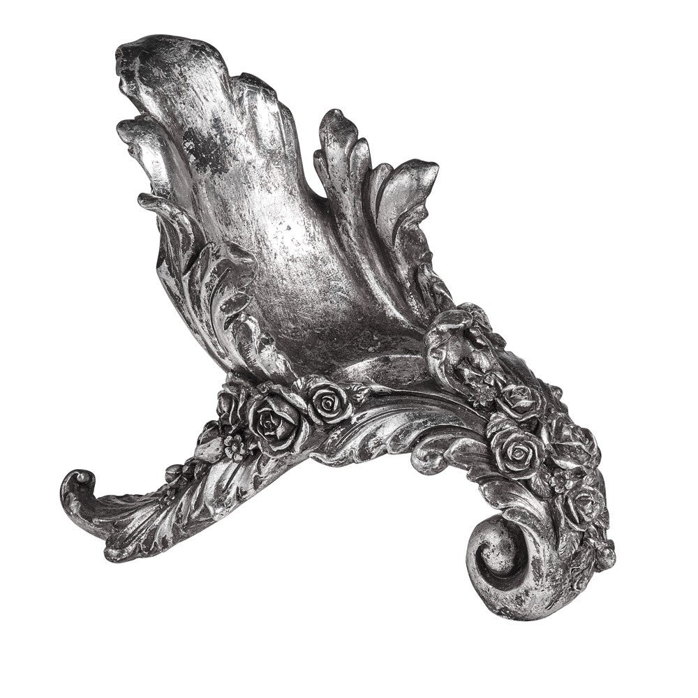 Decorative silver object with floral and leaf designs on a white background