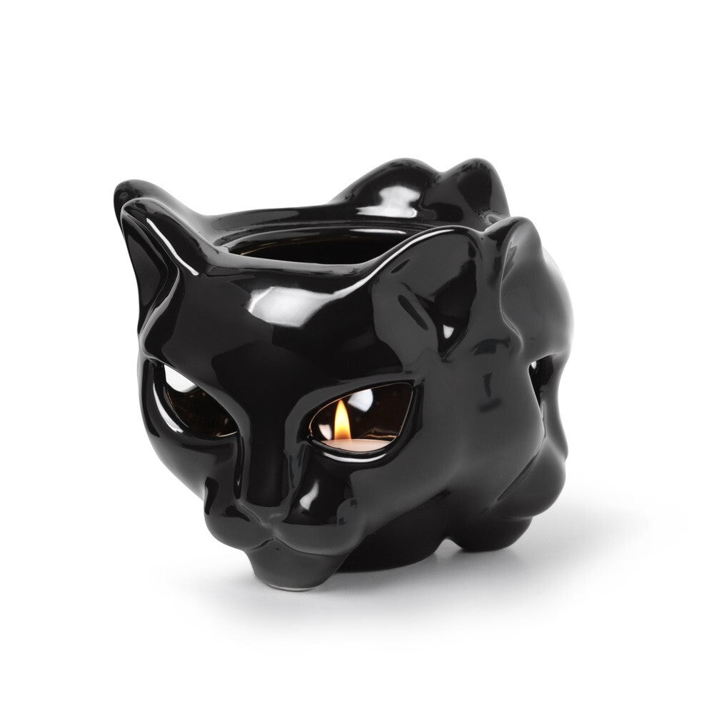 Black cat-shaped candle holder with a lit candle inside on a white background