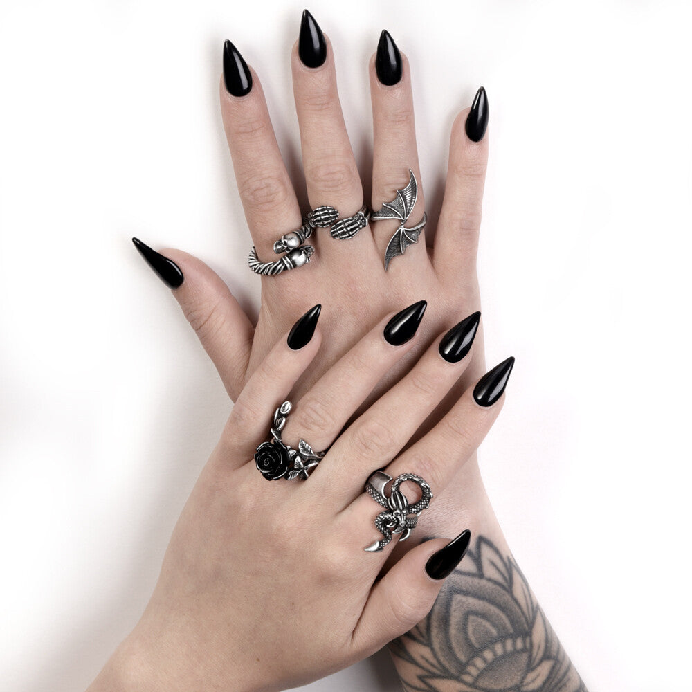Hand with black nail polish and multiple silver rings on a white background