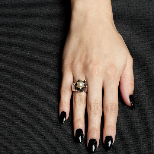 Hand with a ring on a black background