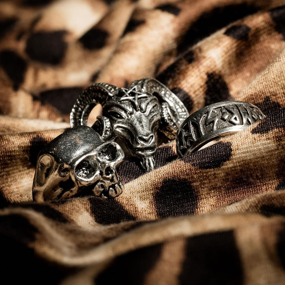 Silver ring with ram and skull design on a leopard print fabric background