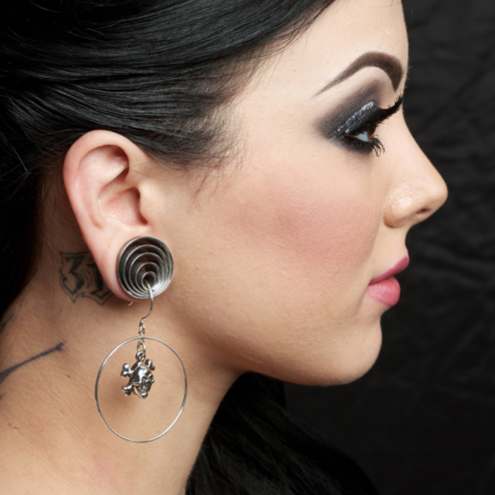 Close-up of a woman's profile wearing large hoop earrings with a dark background
